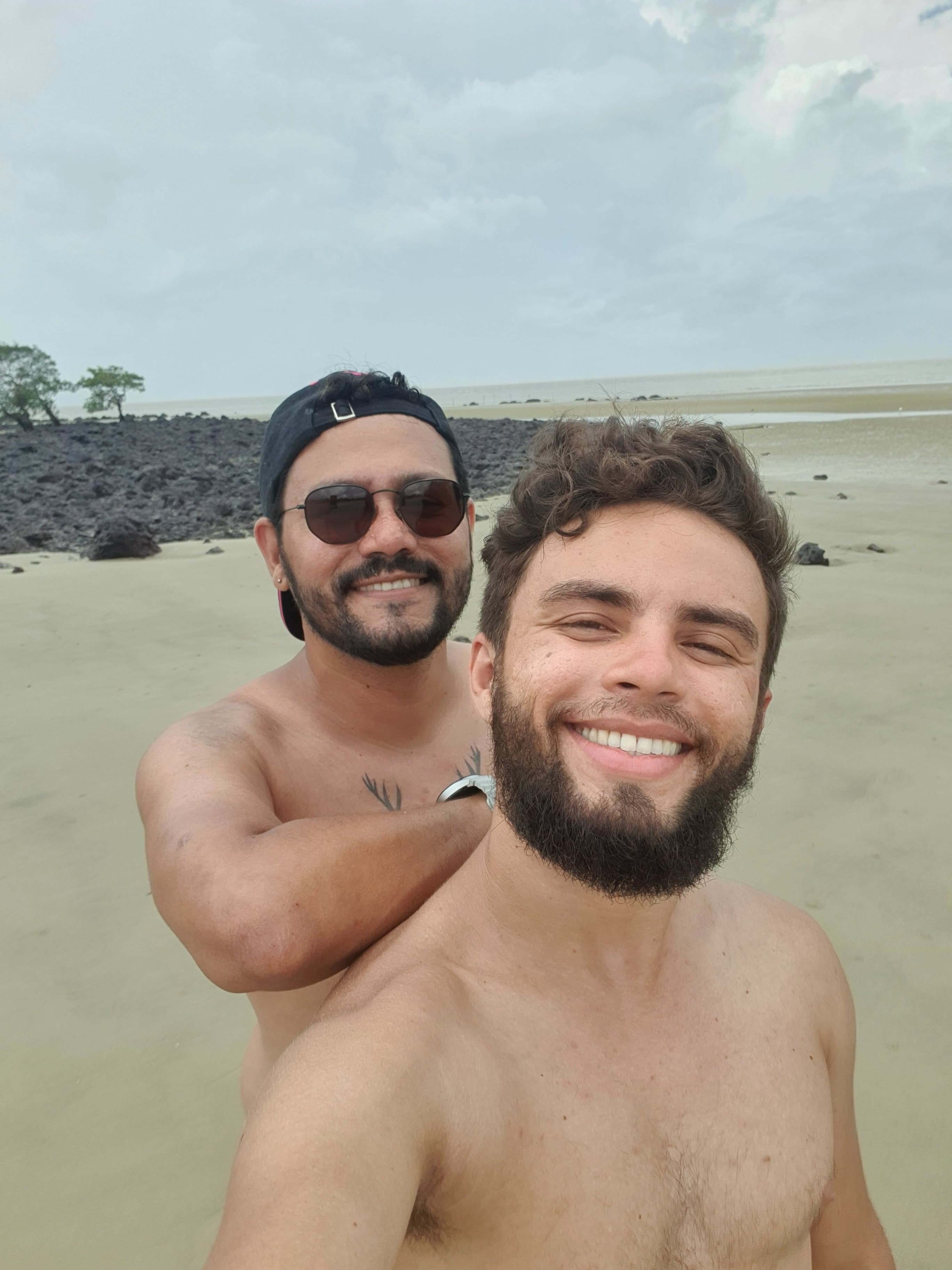 Venilson e Walterly sorrindo juntos em selfie na praia